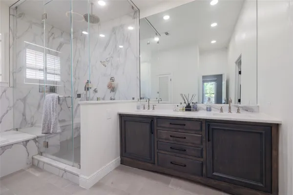 a bathroom with a double vanity sink mirror and bathtub