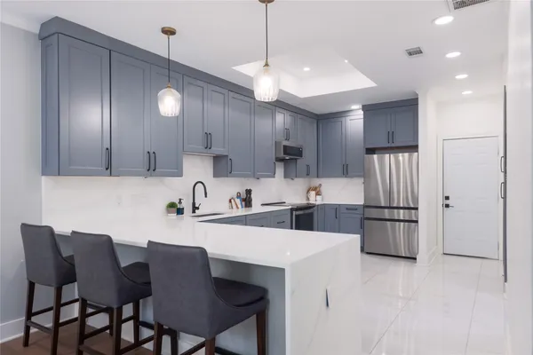 a kitchen with a dining table chairs refrigerator and microwave