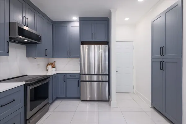 a kitchen with stainless steel appliances granite countertop a refrigerator and a stove top oven