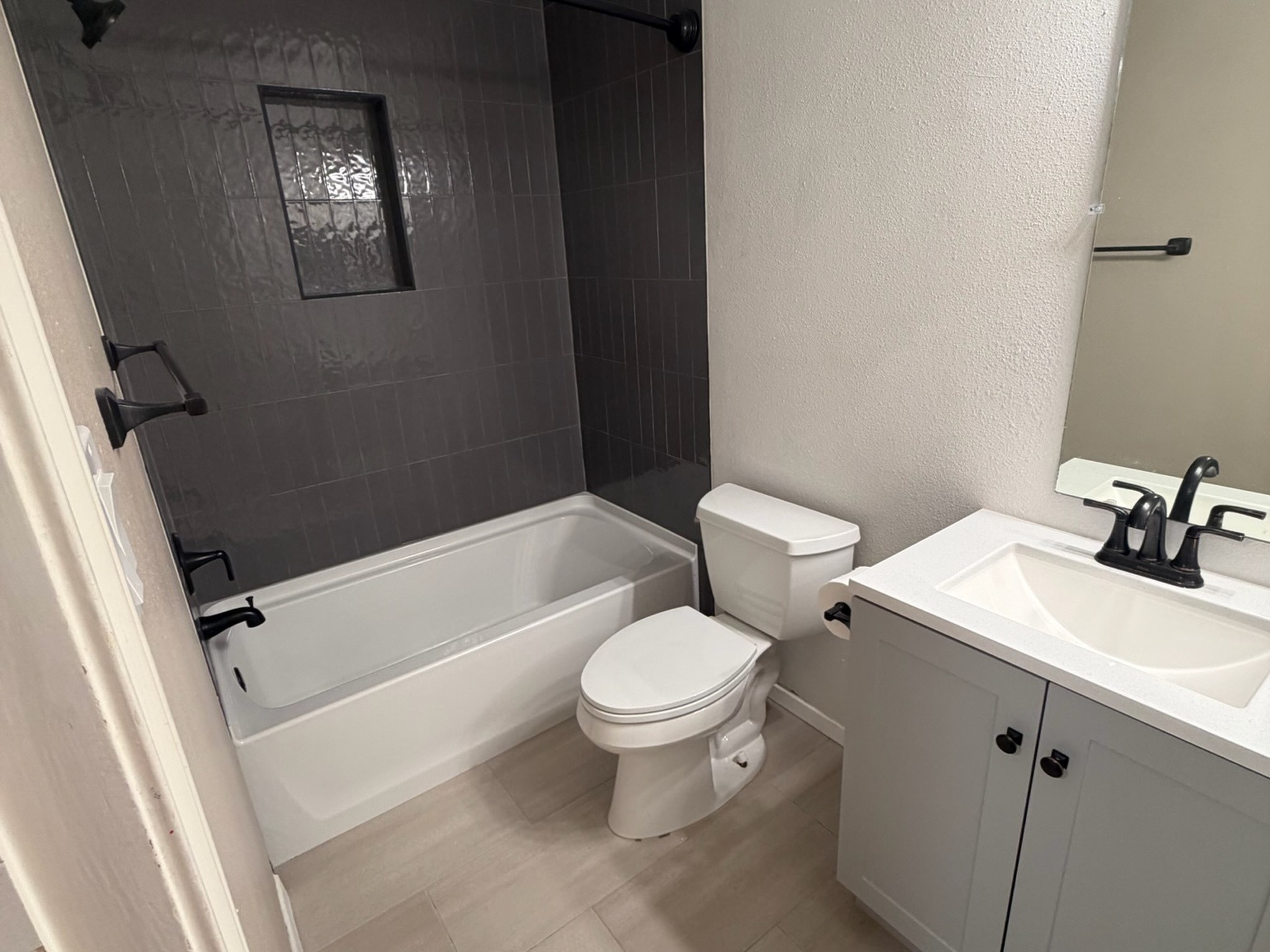 3500 Tangle Brush Drive, Unit 65 Spring, TX 77381 - Photo 14 of 20 Primary bath redone with a new tub, dark tile surround, shaker vanity, black fixtures, and new lighting.