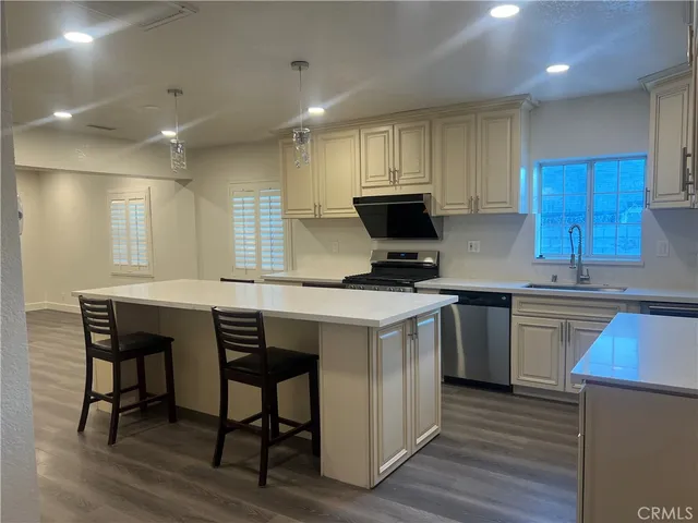 a kitchen with a sink cabinets and wooden floor
