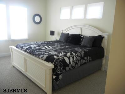 1301 West Avenue, Unit B Ocean City, NJ 08226 - Photo 6 of 11 a bed sitting in a bedroom next to a window
