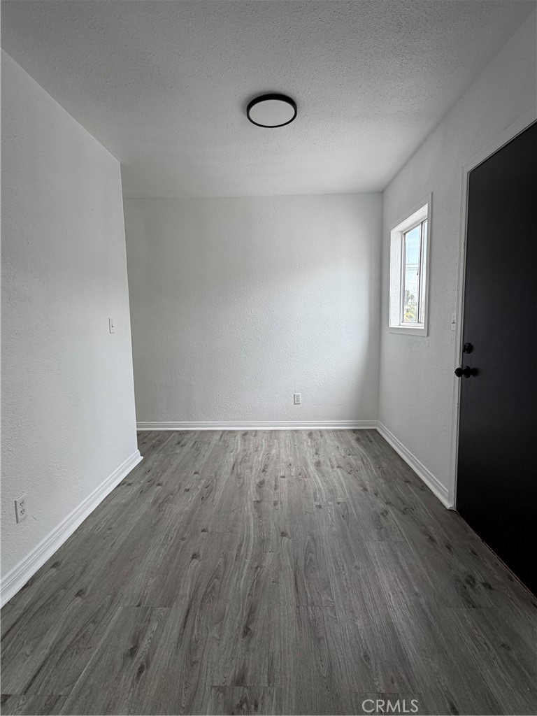 304 West Cedar Street Compton, CA 90220 - Photo 4 of 9 an empty room with wooden floor and windows