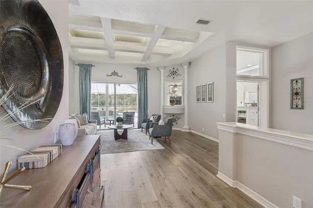a view of a dining room with furniture a chandelier and wooden floor