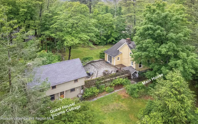 an aerial view of a house with a yard and a large tree