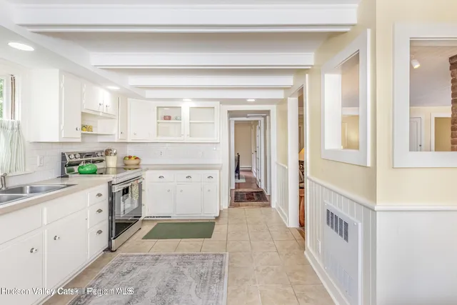 a kitchen with stainless steel appliances white cabinets and a window