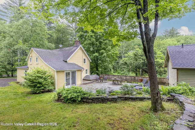 a view of a house with a yard and a tree