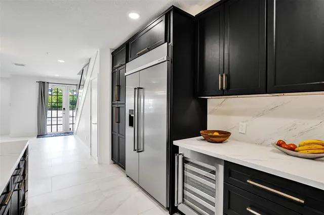 a kitchen with kitchen island granite countertop stainless steel appliances cabinets a sink and a refrigerator