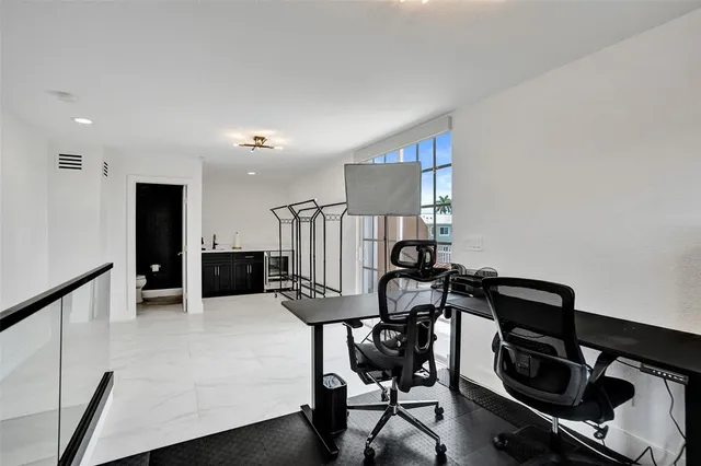 a view of a workspace with furniture and a window