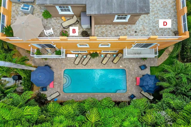 a view of a patio with couches table and chairs under an umbrella