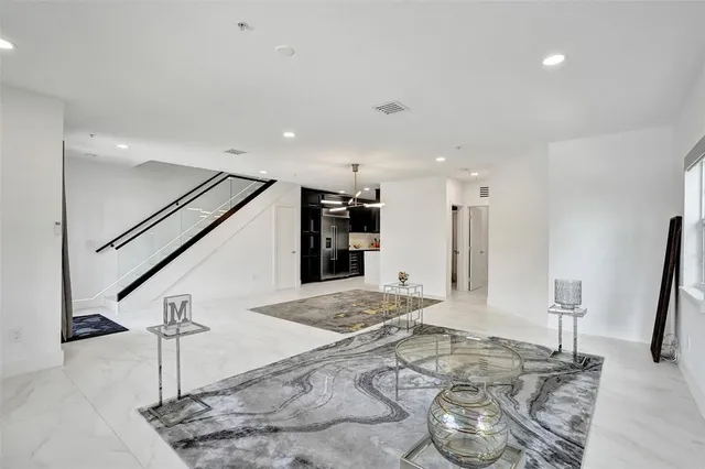 a view of a kitchen with kitchen island a sink wooden floor and a chandelier