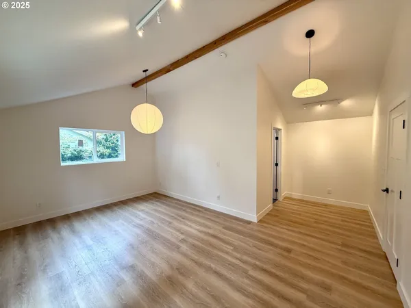 a view of a room with wooden floor and white walls