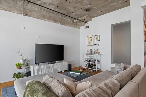a living room with furniture a potted plant and a table