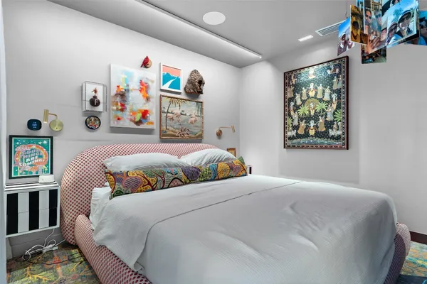 a bedroom with a bed and a painting on the wall