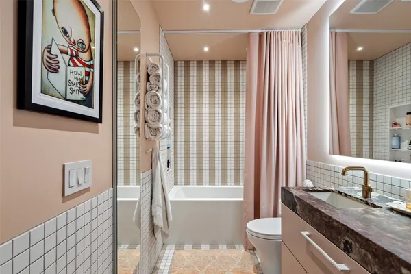 a bathroom with a granite countertop sink toilet and shower
