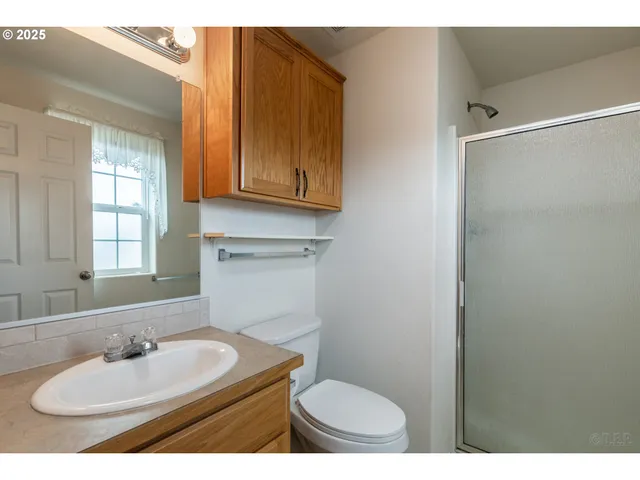 a bathroom with a sink toilet a mirror and shower