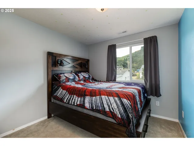 a bed sitting in a bedroom next to a window