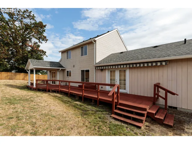 a view of a house with wooden deck and furniture