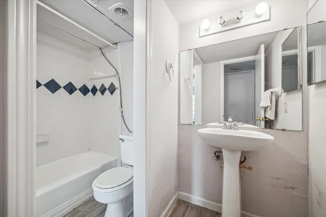 a bathroom with a sink a toilet and shower