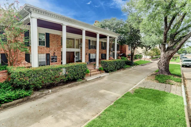front view of a brick house with a yard