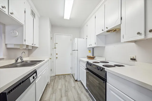 a kitchen with stainless steel appliances a sink dishwasher stove refrigerator and cabinets with wooden floor