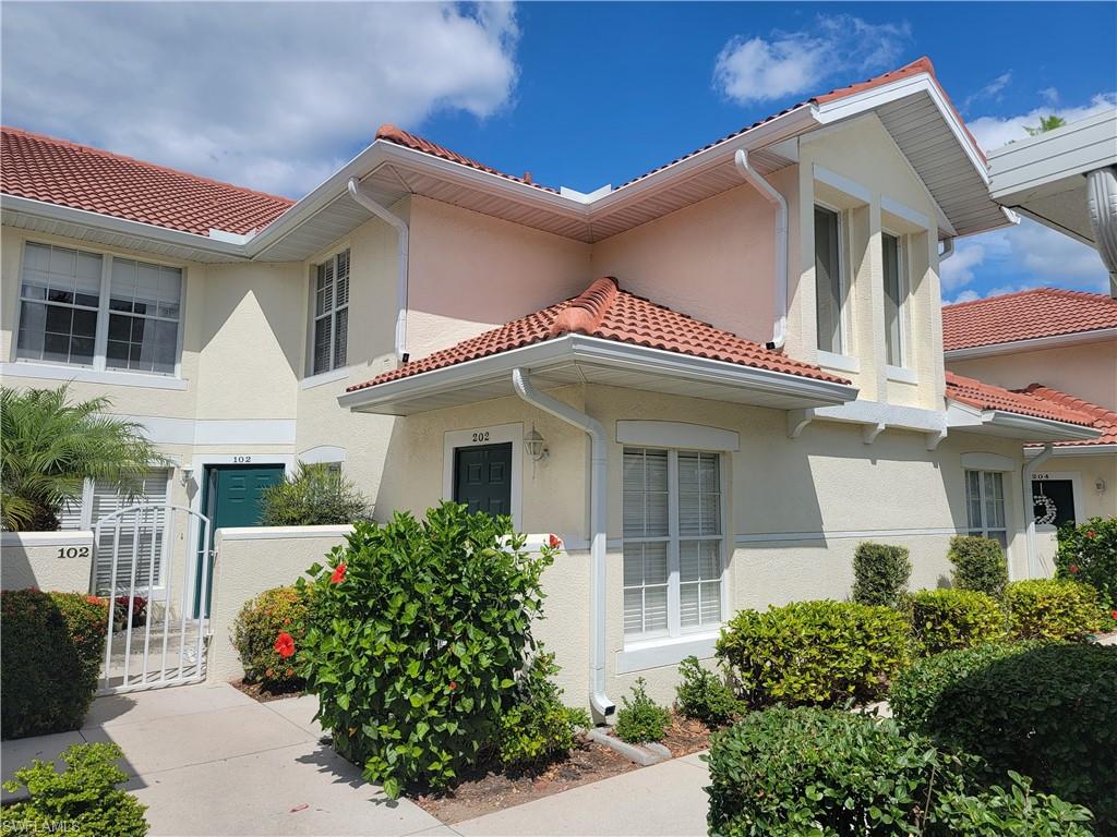 4950 Deerfield Way, Unit D202 Naples, FL 34110 - Photo 1 of 21 a front view of a house with garden