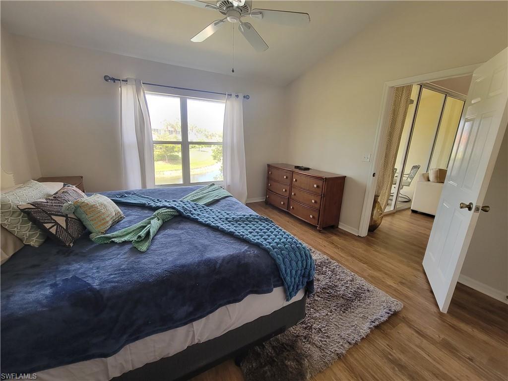 4950 Deerfield Way, Unit D202 Naples, FL 34110 - Photo 12 of 21 a bedroom with a bed and wooden floor
