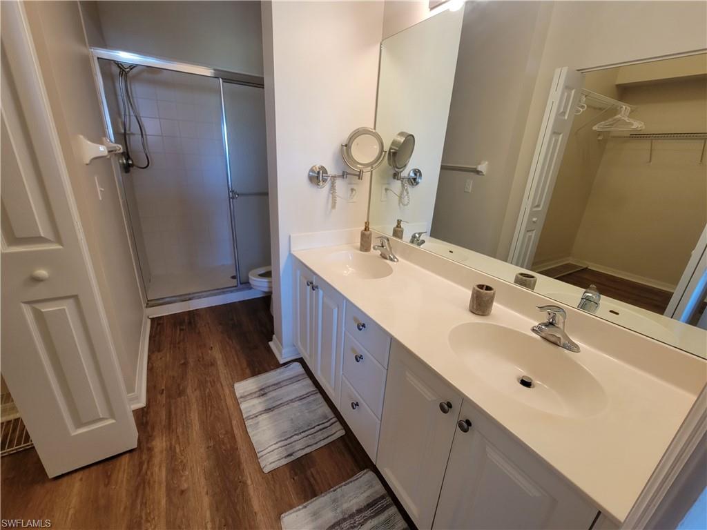 4950 Deerfield Way, Unit D202 Naples, FL 34110 - Photo 13 of 21 a spacious bathroom with a double vanity sink and mirror