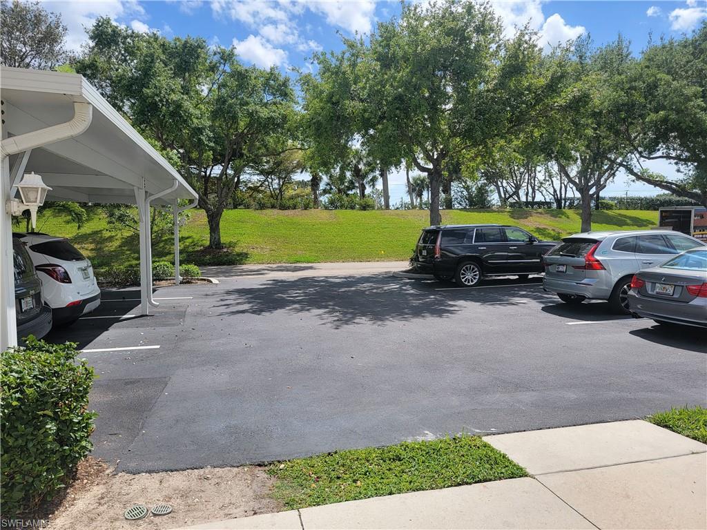 4950 Deerfield Way, Unit D202 Naples, FL 34110 - Photo 19 of 21 a view of a street with a car parked on the road