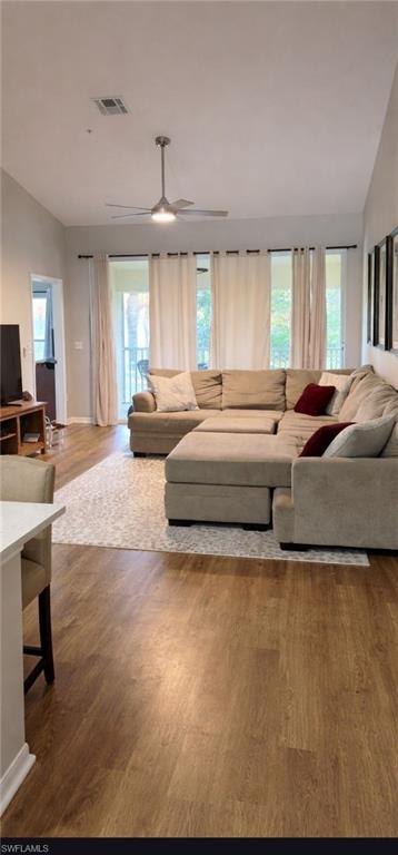 4950 Deerfield Way, Unit D202 Naples, FL 34110 - Photo 20 of 21 a spacious bedroom with a bed a couch and large windows