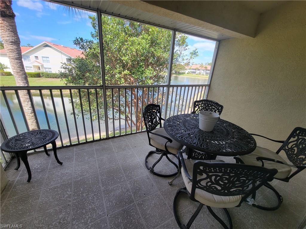 4950 Deerfield Way, Unit D202 Naples, FL 34110 - Photo 2 of 21 a table and chairs in a room and floor to ceiling window