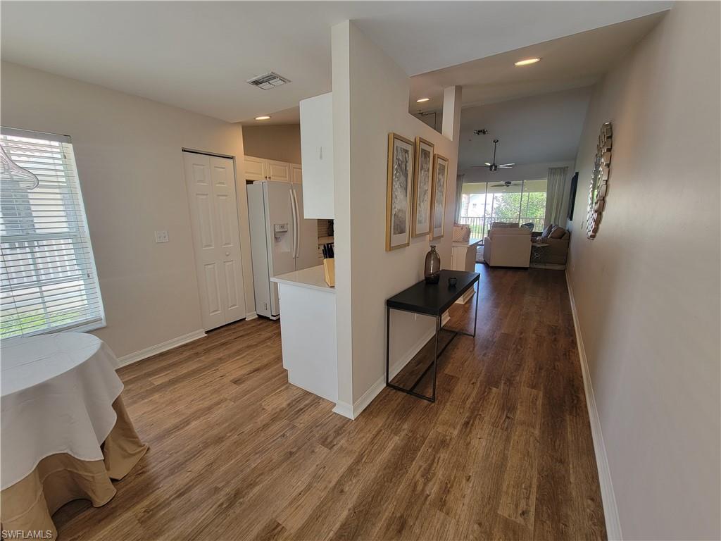 4950 Deerfield Way, Unit D202 Naples, FL 34110 - Photo 4 of 21 a view of a hallway with wooden floor and staircase