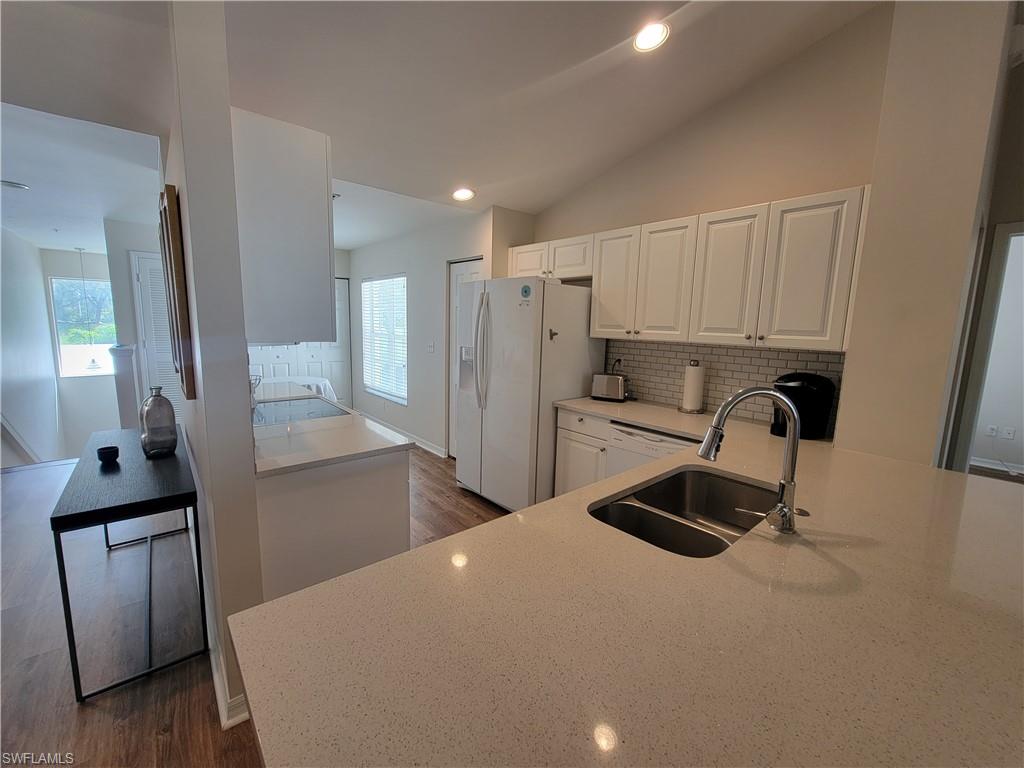 4950 Deerfield Way, Unit D202 Naples, FL 34110 - Photo 9 of 21 a kitchen with refrigerator and window