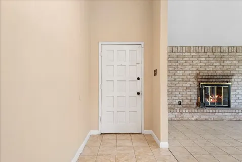 a view of an empty room with a fireplace and a window