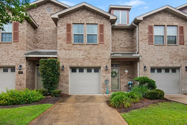 a front view of a house with a garden and plants