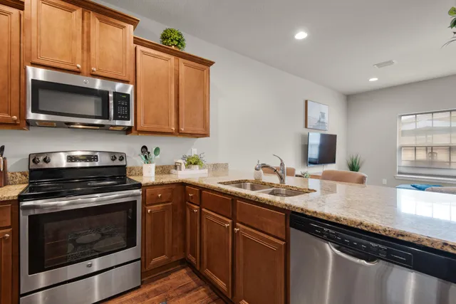 a kitchen with stainless steel appliances granite countertop a sink stove microwave and cabinets