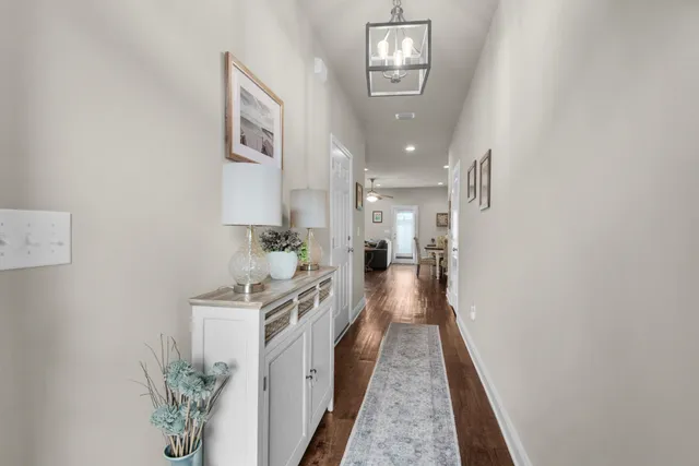 a walk in closet with wooden floor