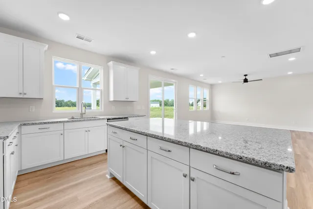 a kitchen with granite countertop cabinets stainless steel appliances a sink and a window