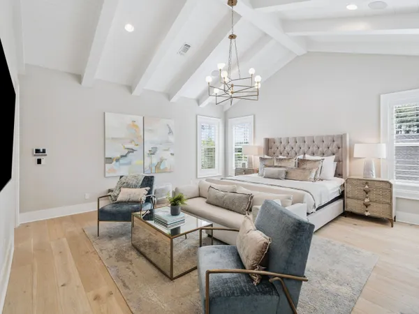 a spacious bedroom with a bed and a chandelier