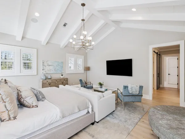 a spacious bedroom with a bed and a chandelier
