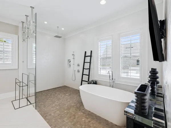 a bathroom with a bathtub and a flat screen tv