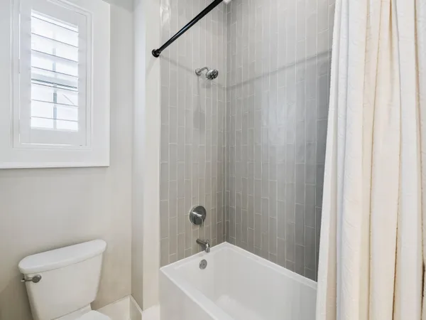 a white bath tub sitting next to a white toilet and a shower