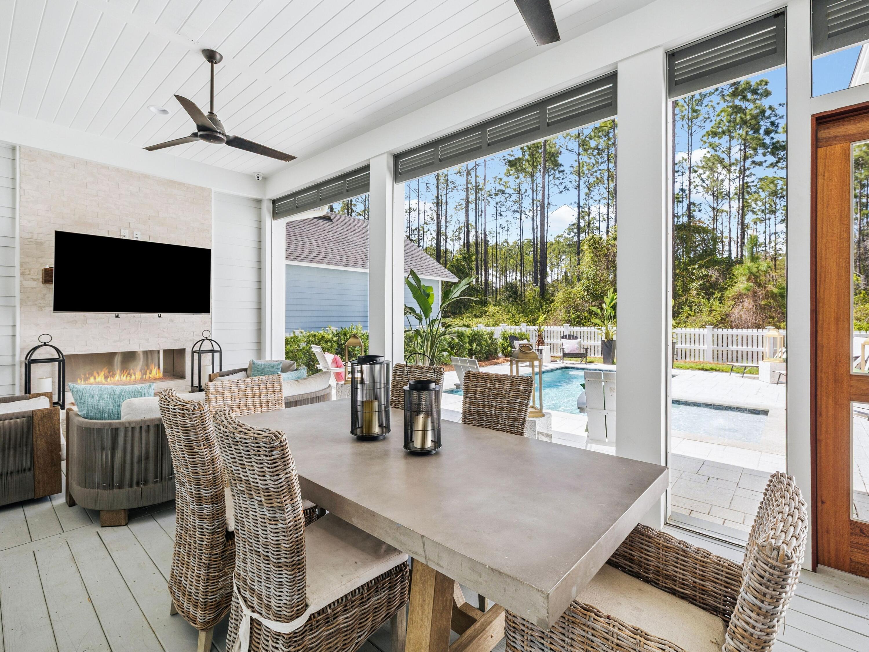 85 Trailhead Drive Watersound, FL 32461 - Photo 33 of 48 a living room with furniture a flat screen tv and floor to ceiling windows