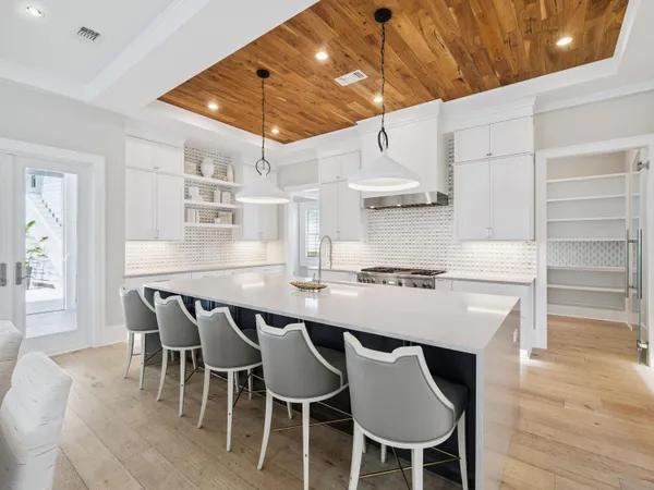 a kitchen with a dining table chairs and white cabinets