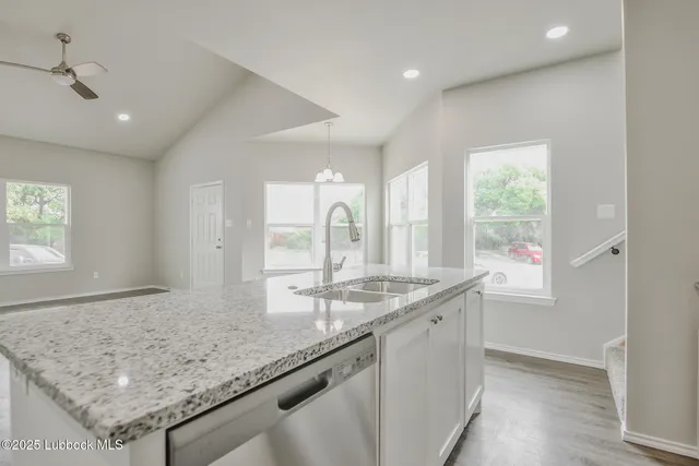 a bathroom with a granite countertop sink and a window