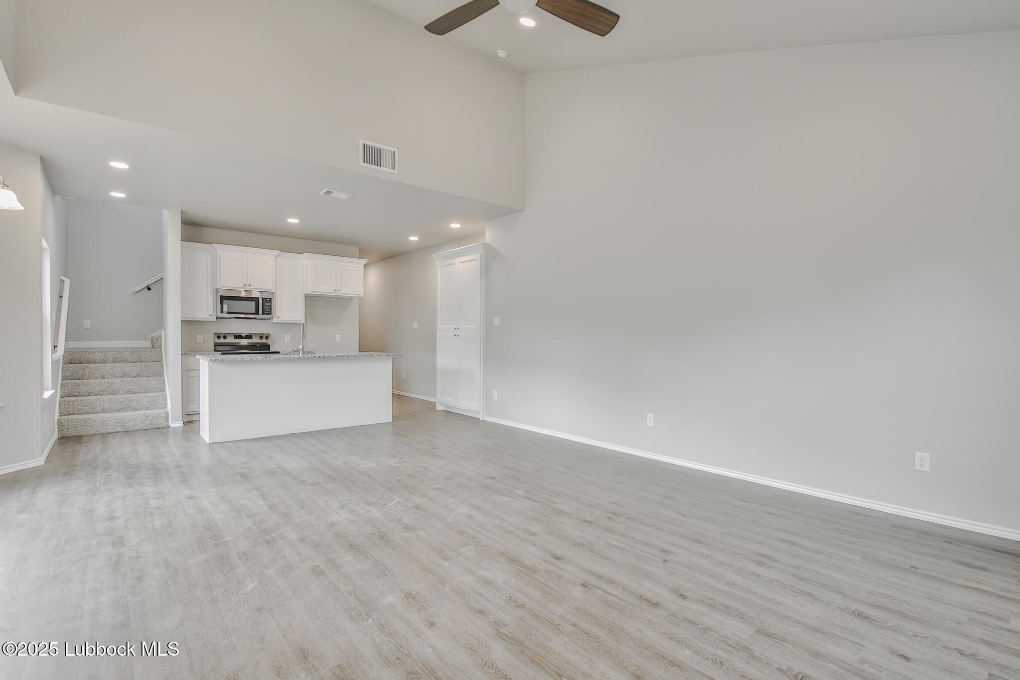 3121 74th Street Lubbock, TX 79423 - Photo 3 of 36 a view of kitchen with refrigerator and white cabinets