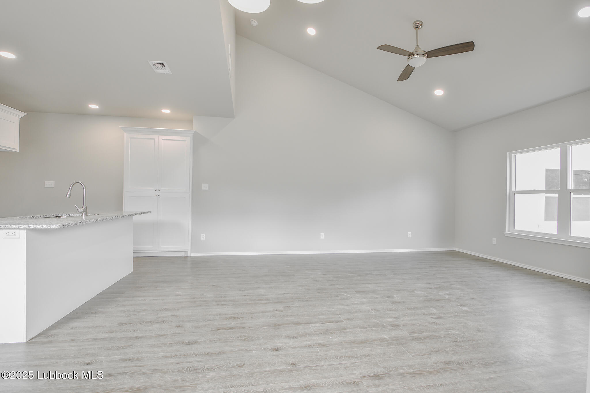 3121 74th Street Lubbock, TX 79423 - Photo 6 of 36 an empty room with wooden floor and windows