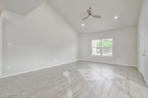an empty room with a window and a ceiling fan