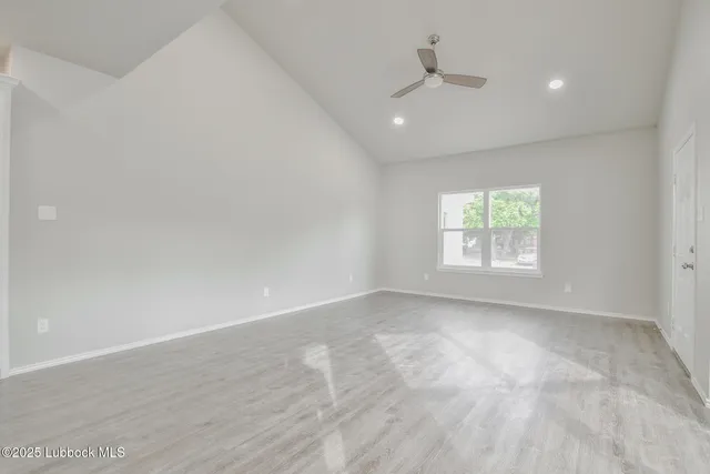 an empty room with a window and a ceiling fan