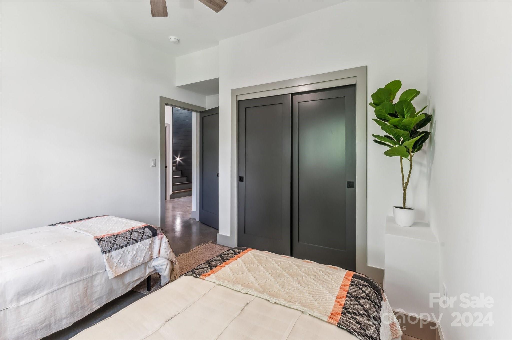 151 Laurel Loop Asheville, NC 28806 - Photo 29 of 35 a bedroom with a bed and a potted plant